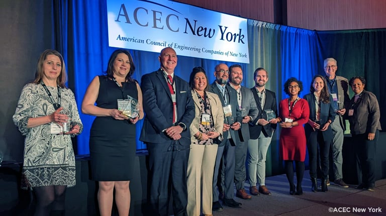 Alex Moscovitz, third from the right, holding the ACEC New York DEI+B Award in a group photo.