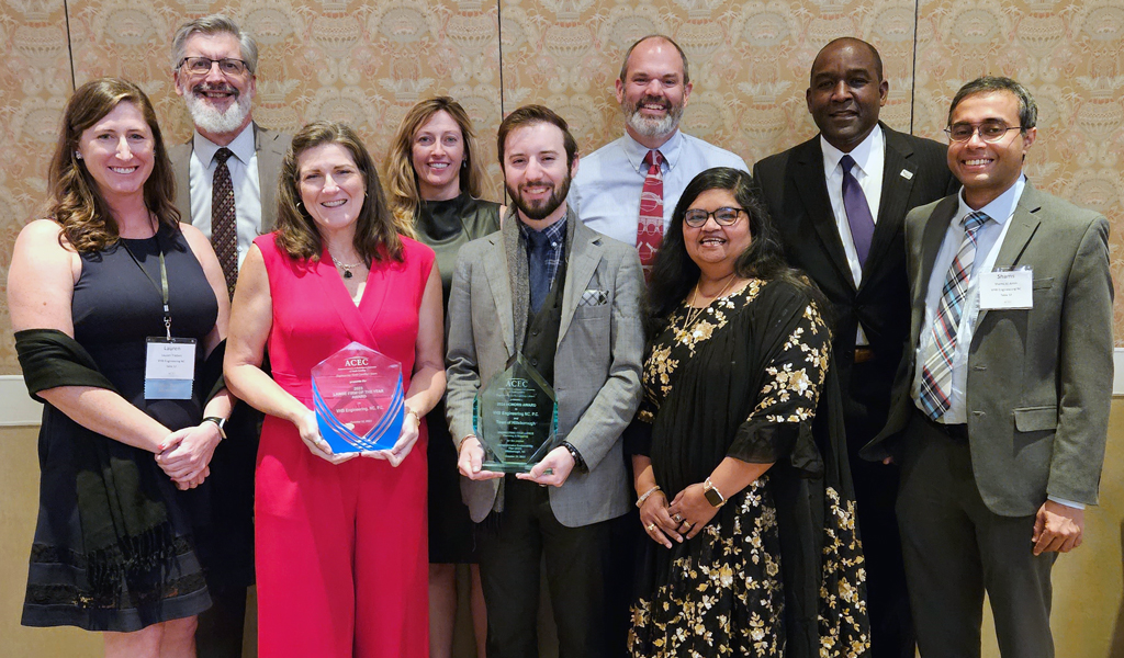 A group of VHBers smile at the camera in a group photo with the awards at the ACEC/NC Awards Gala. 