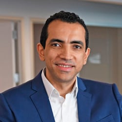 Man wearing a blue suit and white shirt in an office setting