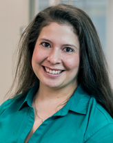 Elizabeth Jule smiling in a teal blouse.