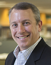 John Eveland wearing a black suit and checkered shirt