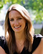 Kristina in a garden smiling.