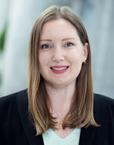 Meghan Powell smiling outside in a dark blazer.