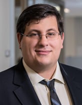 Michael DeGaspari smiling in black suit.