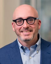 Michael Goldemberg smiling in a navy blue jacket.