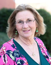 Rebecca Francese smiling outside in a floral shirt.