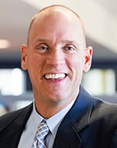 Rob Smedberg smiling, wearing a navy blazer.