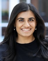 Serena Singh smiles at the camera in a black shirt.