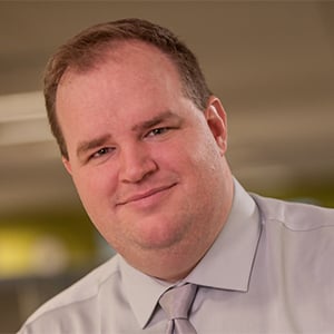 Keith in a light colored short and tie in an office setting.