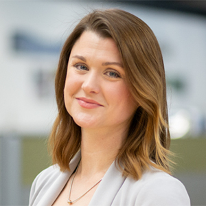 Woman wearing a light gray suit in an office setting