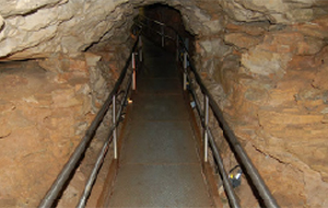 Metal hand rails flank a walking path inside a cave