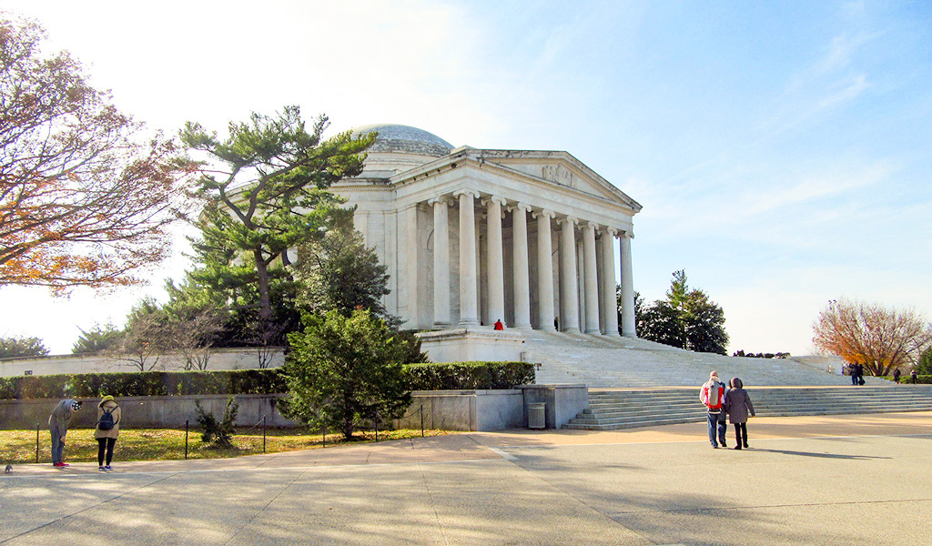 Pedestrians stand in front of the staircase and front entrance to the Thomas Jefferson Memorial in Washington, DC.