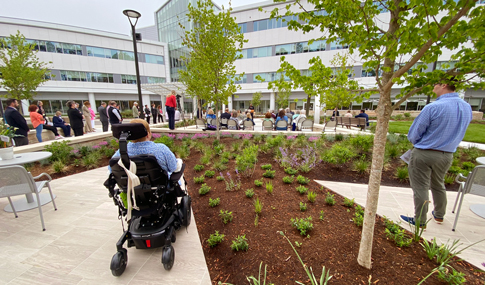 An individual in a wheelchair watches the Sheltering Arms Hospital ribbon cutting ceremony events. 