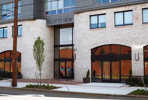 Front entrance to Scott’s View Apartments that includes new trees and plantings along the urban streetscape. 