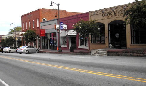 An historic downtown street with brick buildings and cars parked in front