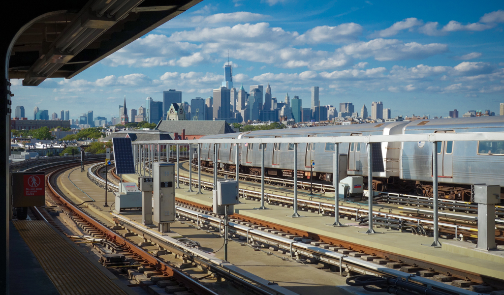 Train station platform in Brooklyn looking toward Manhattan skyline.