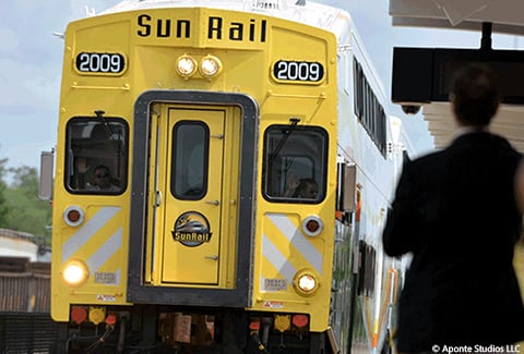A man waits to board an incoming SunRail train.