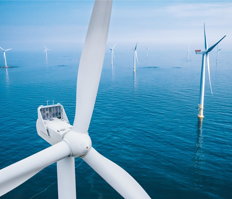 Aerial view of wind turbines or windmills farm field in blue sea