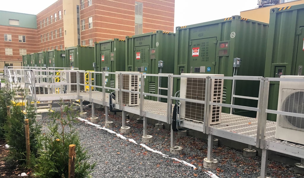Green industrial battery containers arranged in a row.