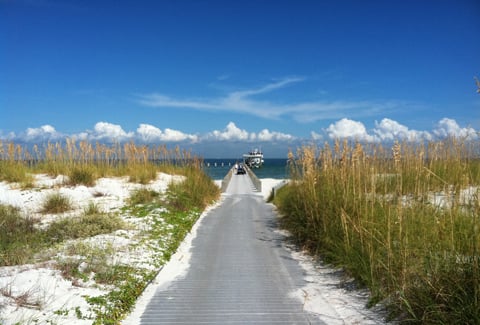 View of water, sandy coastline and pier at Gulf Islands National Seashore.