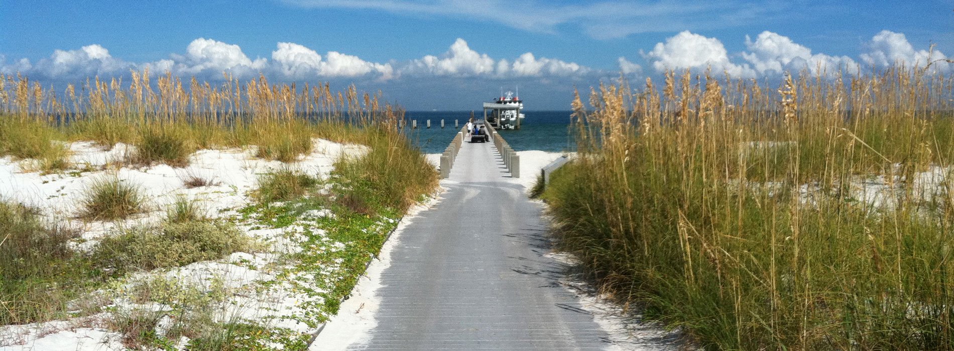 View of water, sandy coastline and pier at Gulf Islands National Seashore.