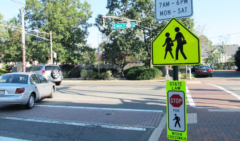A traffic sign to promote pedestrian safety at an intersection. 