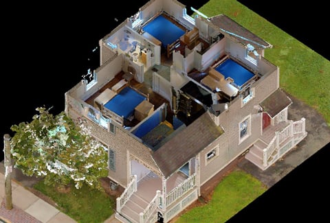 Isometric view of a detailed, cutaway digital model of a two-story house showing interior rooms and furnishings, surrounded by a small yard with a tree and sidewalk.