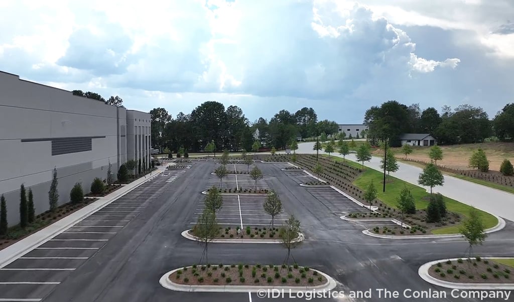 Industrial facility parking lot with landscaped islands and perimeter plantings.