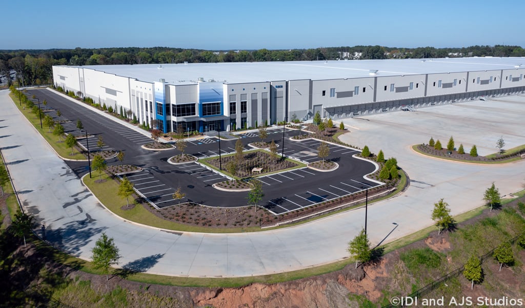 Oblique aerial of a logistics facility depicting parking, landscape, and loading docks.