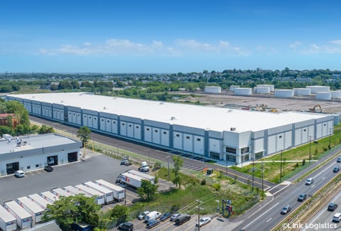 Oblique aerial of a large warehouse on a sunny day with blue skies.
