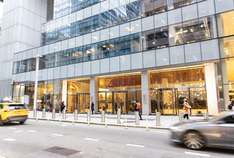 City building with cars driving by.