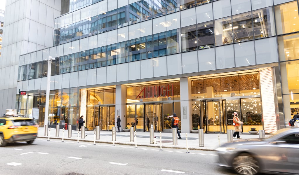 City building with cars driving by.