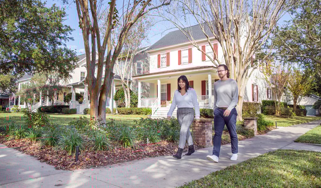 A couple strolling in a residential neighborhood in Florida on a sunny day.