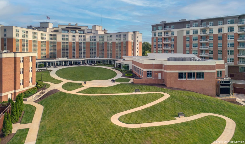 Aerial view of the Westminster at Canterbury campus with brick buildings and green open space set against a blue sky.
