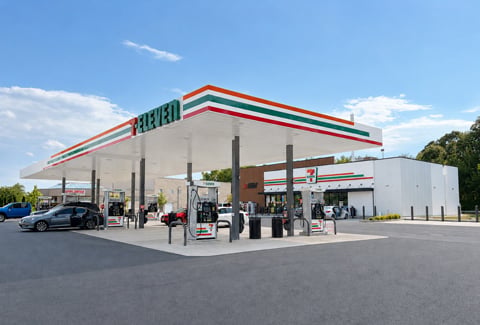 7-Eleven gas station and convenience store on a partially cloudy day with blue sky. 