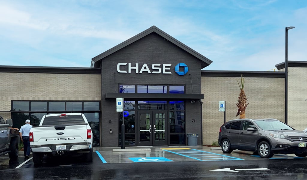 Front entry of Chase Bank with a brown car and white truck parked alongside handicapped spaces.