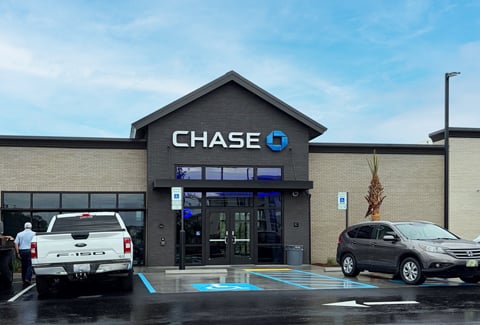 Front entry of Chase Bank with a brown car and white truck parked alongside handicapped spaces.
