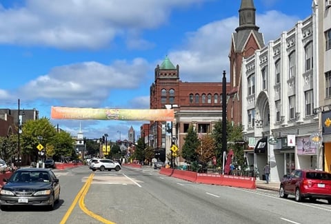 View of a vibrant main street area featuring historic buildings and cars under a clear blue sky.