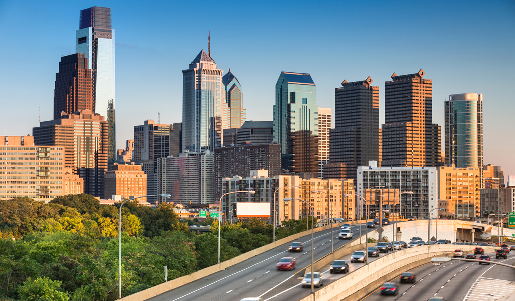 Philadelphia skyline with freeway traffic in the foreground.