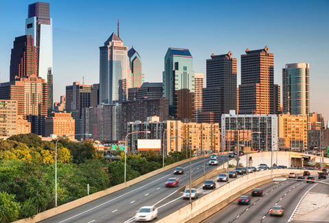Philadelphia skyline with freeway traffic in the foreground.