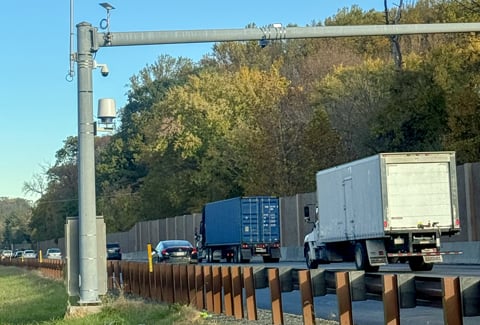 I-476-Hard-Shoulder-Running-1: Trucks and cars driving under a vehicle detection system.