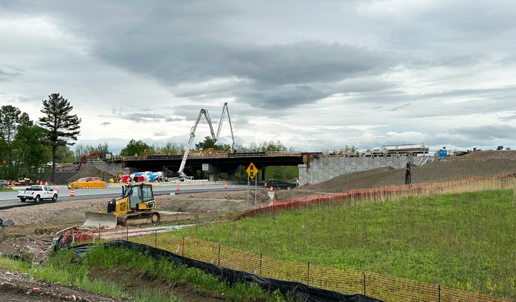 A highway construction site with construction vehicles and a crane.