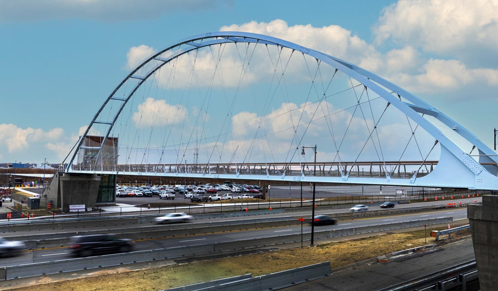 A blue pedestrian bridge over highway.