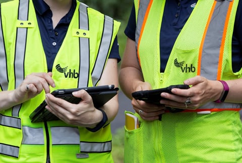 Two VHB Employees use tablets during an environmental site visit