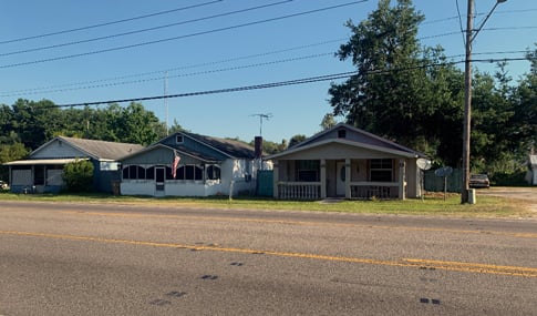 Three historic houses on the side of a road