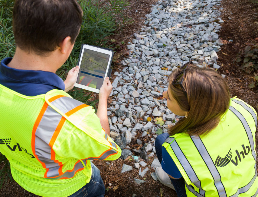 Two water resource engineers collect data in the field. 