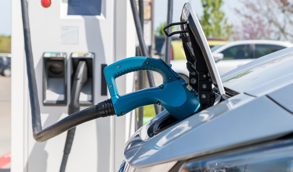 Electric car plugged in to charge battery at a charging station