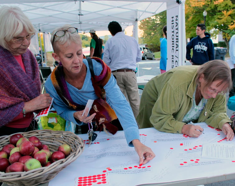 Three women work on an activity at an outdoor event.