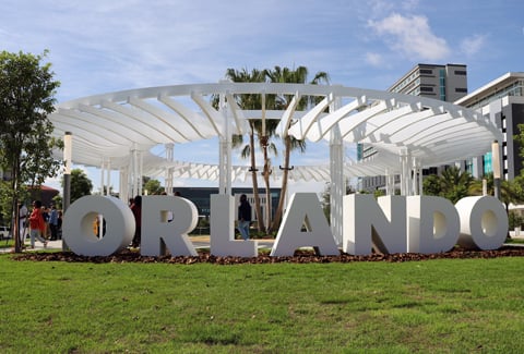 A white sculpture in a park that spells out the word Orlando.
