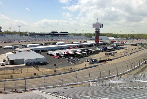 View of the Richmond International Raceway from the stands that shows the track, center leaderboard, and garage area.